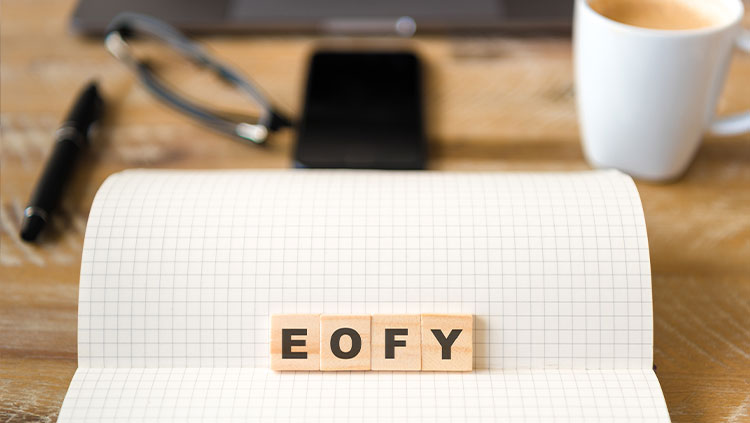 Desk with EOFY in block letters with coffee and phone